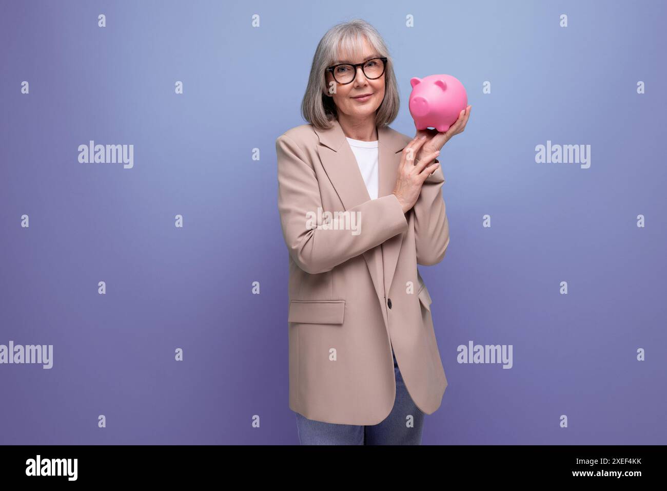 Riche vieille femme avec une tirelire d'argent sur un fond lumineux avec espace de copie Banque D'Images