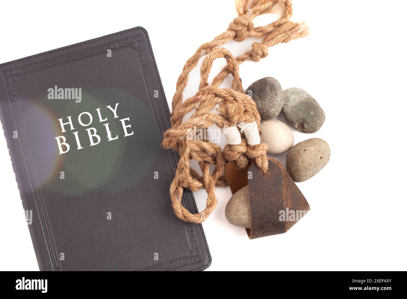 Sling Shot and Stones on a White background de l'histoire de David et Goliath dans la Bible Banque D'Images