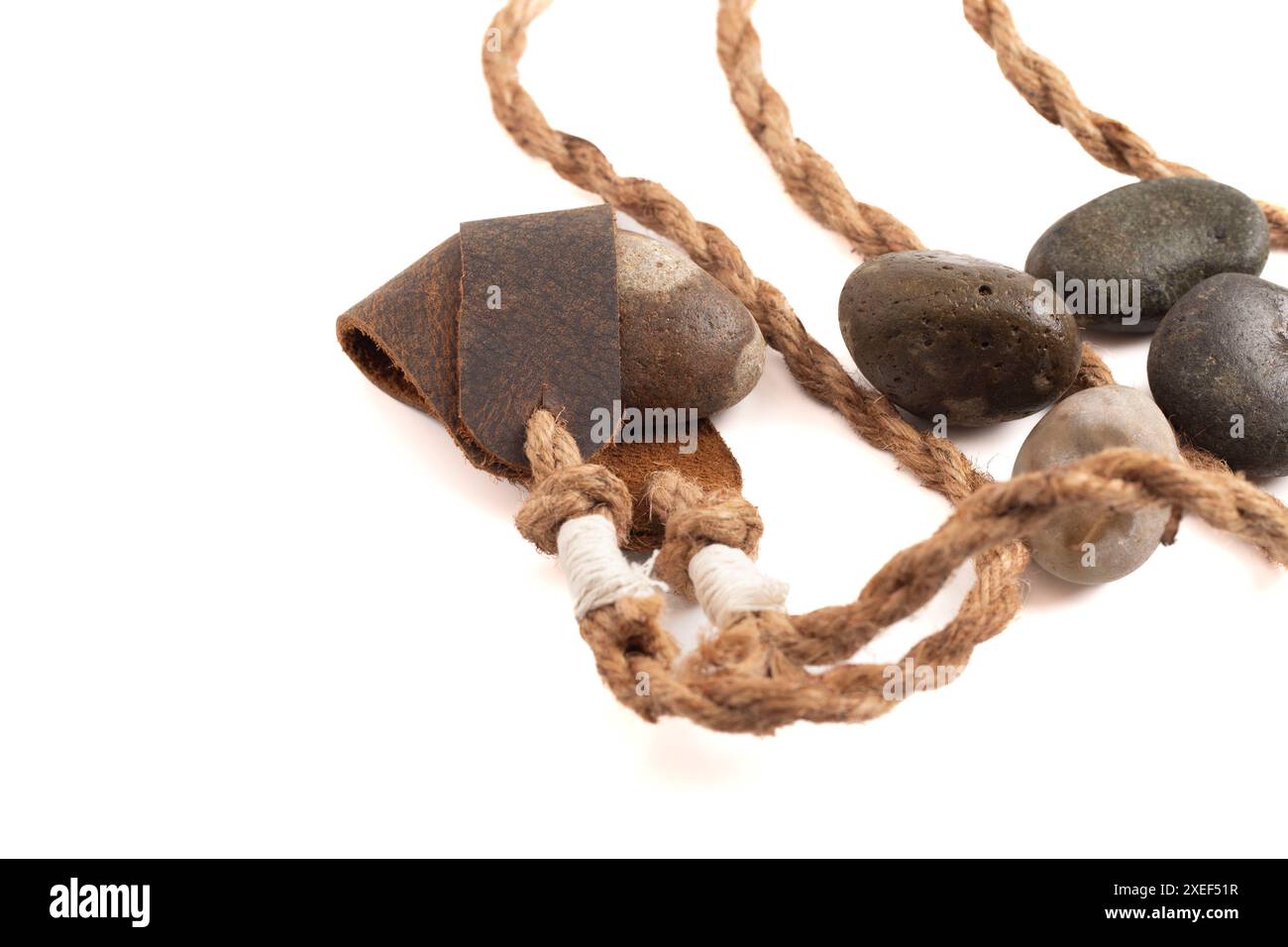Sling Shot and Stones on a White background de l'histoire de David et Goliath dans la Bible Banque D'Images