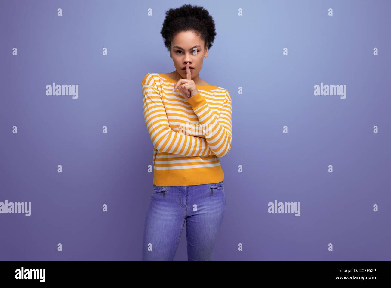 Modèle Latina jeune femme avec cheveux afro sur fond de studio Banque D'Images