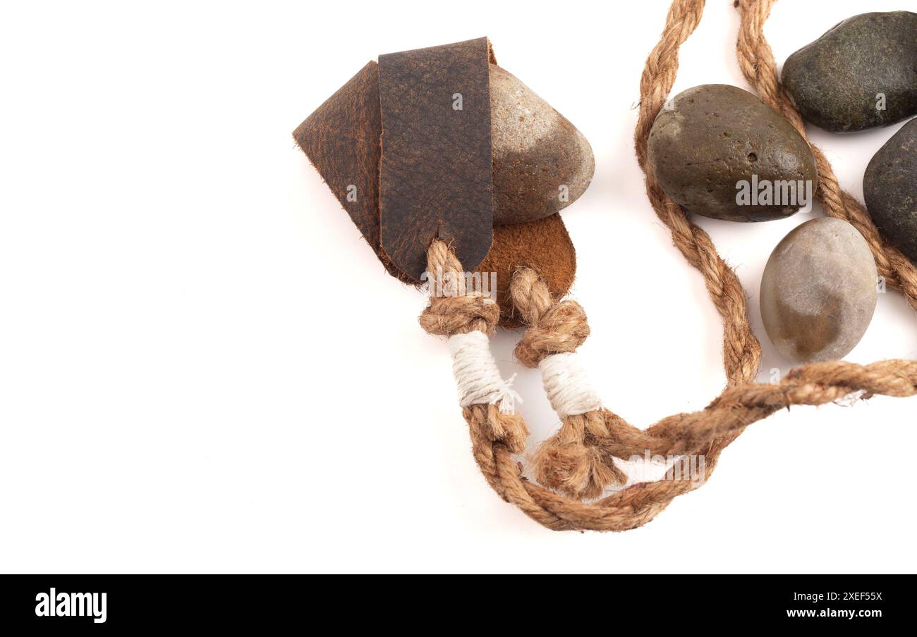 Sling Shot and Stones on a White background de l'histoire de David et Goliath dans la Bible Banque D'Images
