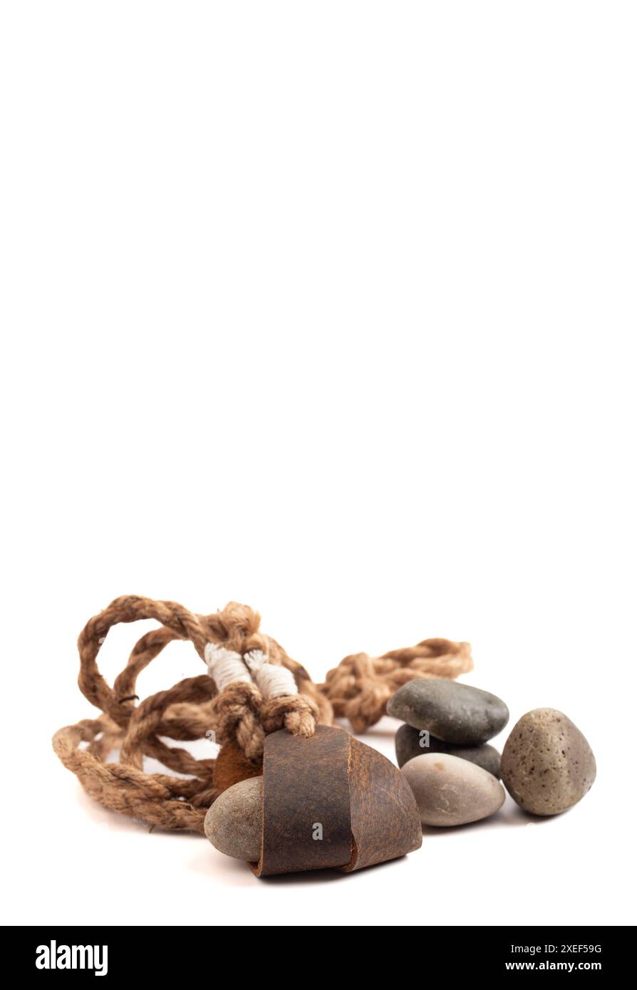 Sling Shot and Stones on a White background de l'histoire de David et Goliath dans la Bible Banque D'Images