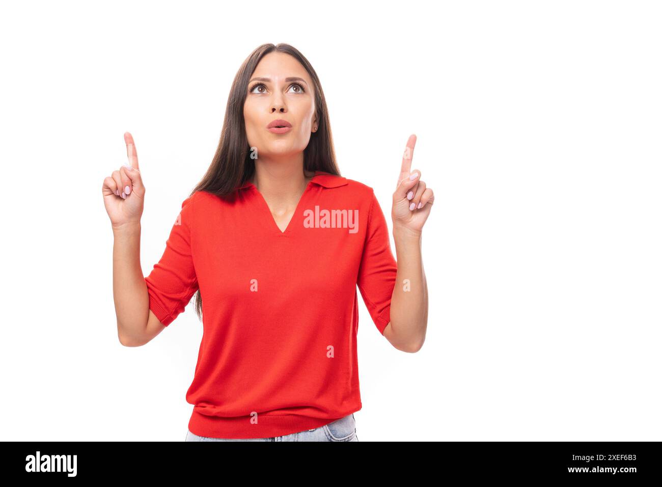 la femme caucasienne âgée de 30 ans avec des cheveux noirs droits habillés dans une chemise à manches courtes rouge garde un secret Banque D'Images