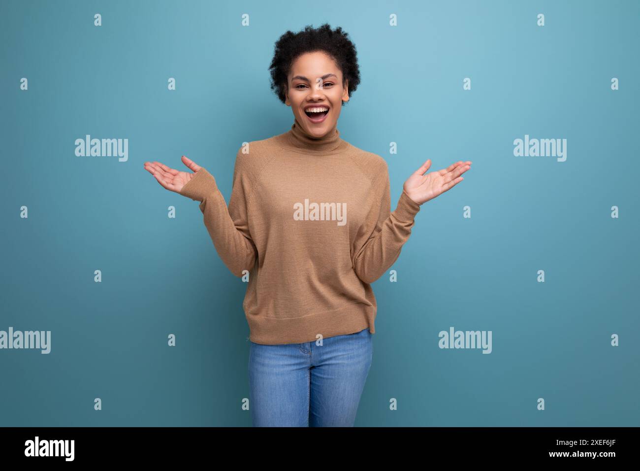 Positive jolie jeune femme avec la peau foncée et les cheveux moelleux est heureuse sur fond isolé avec espace de copie Banque D'Images