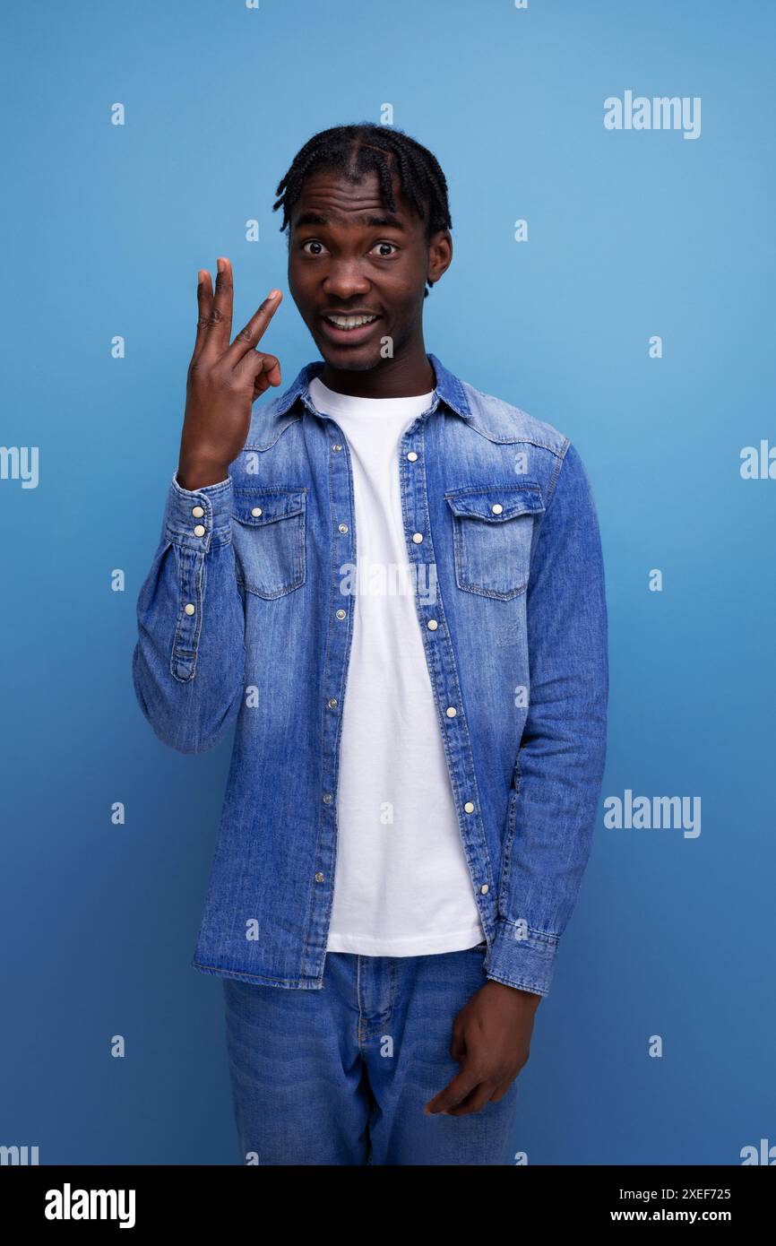 Homme africain intelligent avec dreadlocks sur fond bleu Banque D'Images