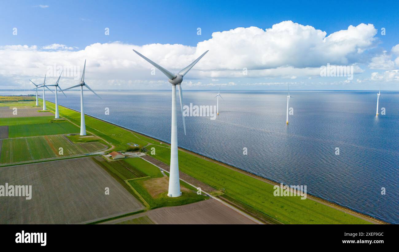 Les éoliennes tournent gracieusement dans un parc éolien perché près de l'océan, exploitant la puissance de la brise pour générer des énergies renouvelables Banque D'Images