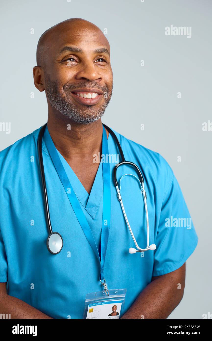 Gros plan Portrait de studio d'un médecin mature souriant portant des gommages sur fond blanc Banque D'Images