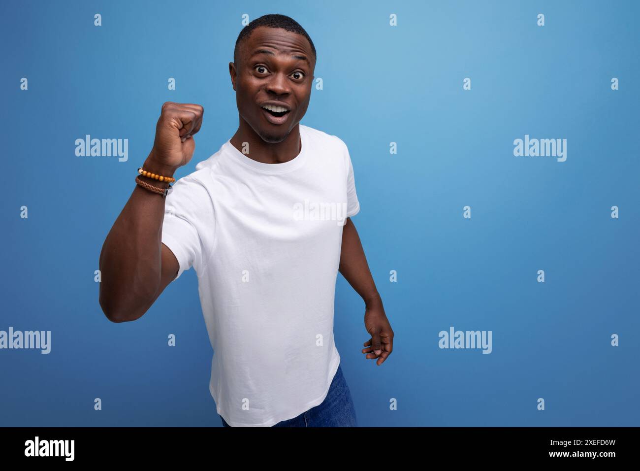 Jeune africain optimiste réussi en t-shirt blanc Banque D'Images