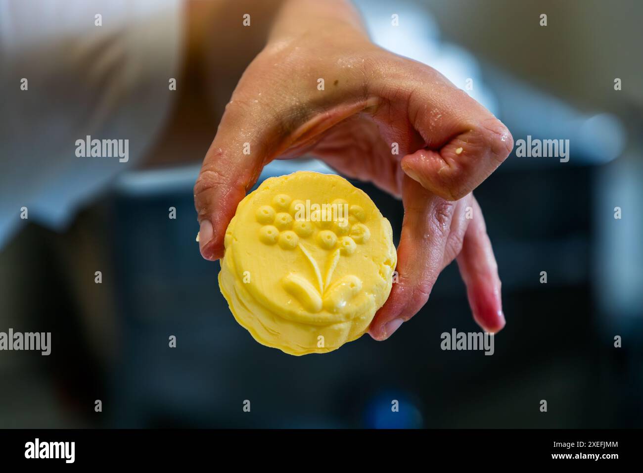 Le beurre alpin jaune doré est découpé en portions à l'aide d'un moule traditionnel en bois. Production de beurre dans la fromagerie appartenant au Filzmoosalm. Promegg, Großarl, Salzbourg, Autriche Banque D'Images