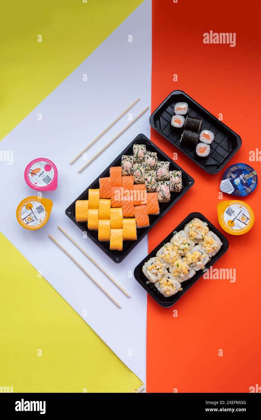 Livraison de sushis. Ensemble de rouleaux dans une boîte jetable sur un fond noir. Vue de dessus Banque D'Images