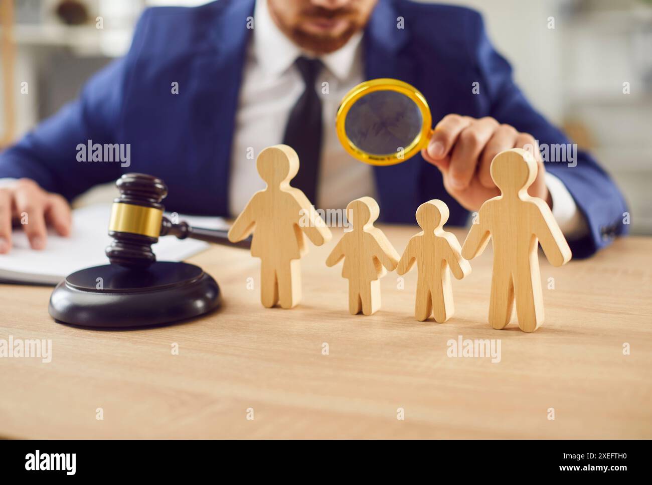 Juge examinant les figures en bois d'Une famille au tribunal Banque D'Images