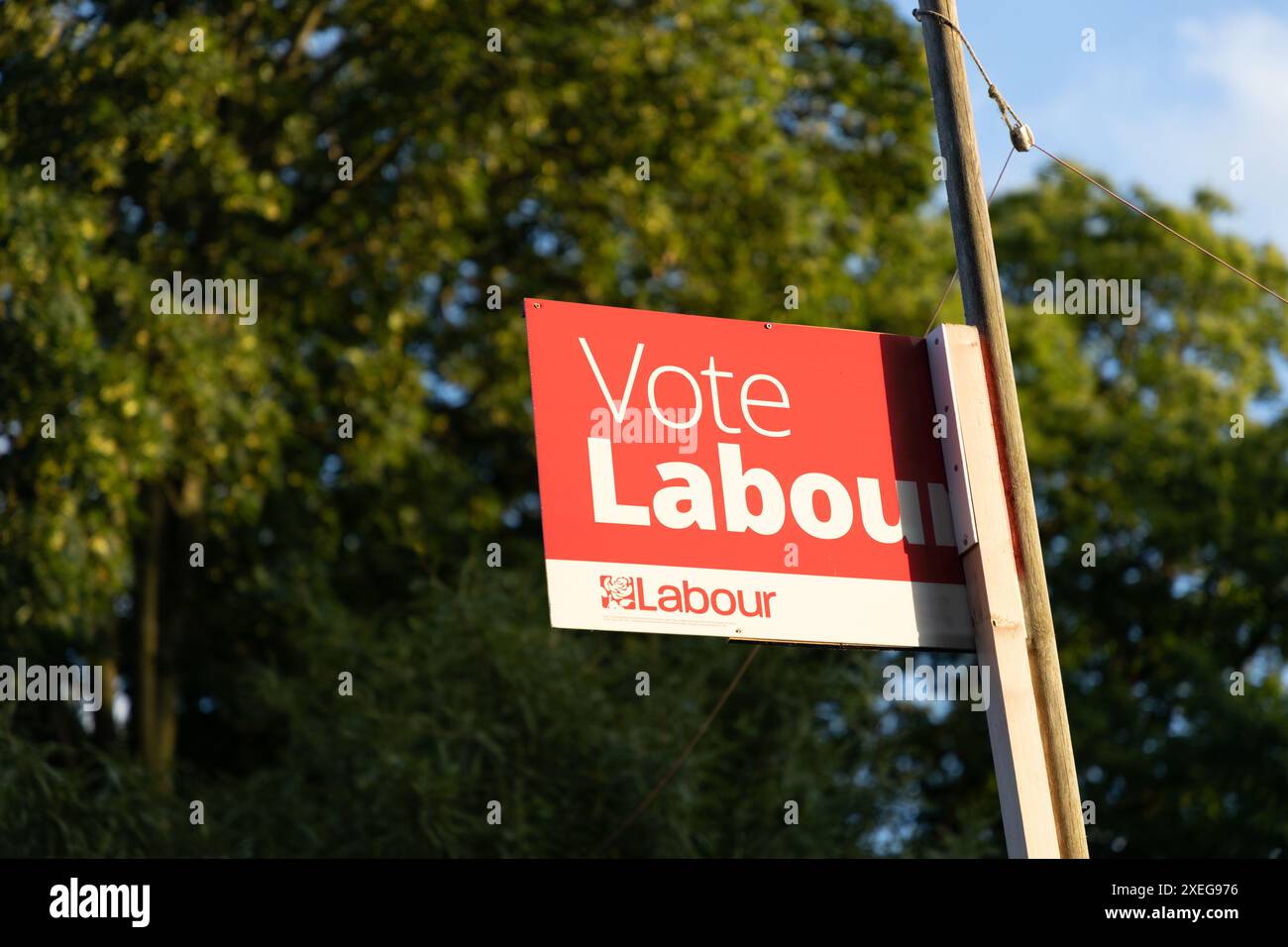 Un panneau affiché pendant les élections britanniques de 2024 qui dit vote Labour pendant une chaude lumière de soirée d'été. Banque D'Images