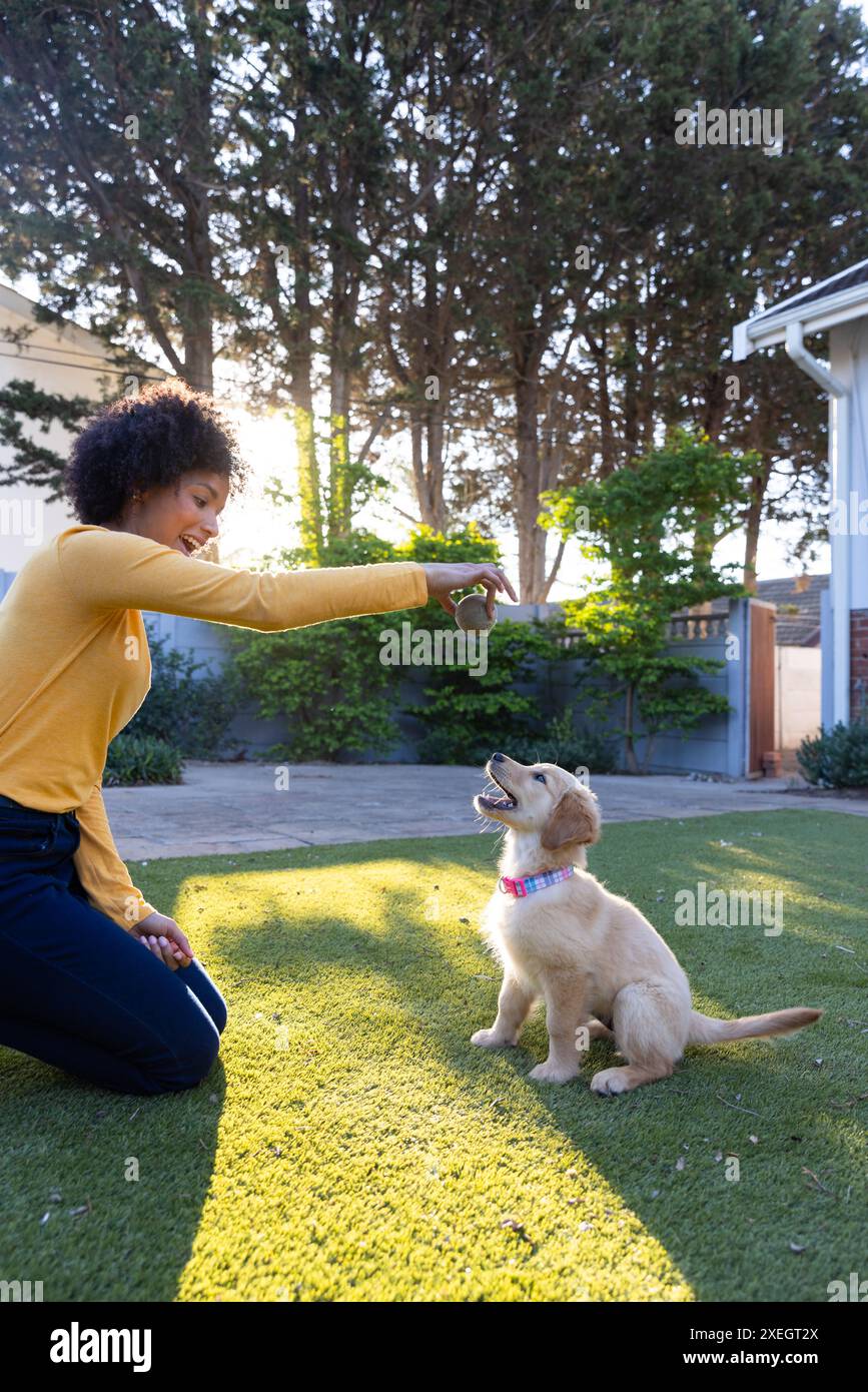 Jouer avec chiot, chien de formation de femme avec jouet dans la cour arrière Banque D'Images