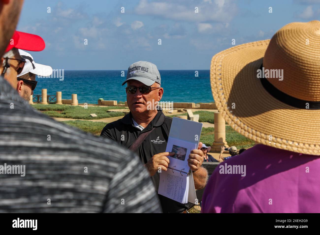 Un chef de groupe signale à son groupe l'emplacement des ruines de Césarée Maritima le long de la côte de la mer Méditerranée en Israël. Banque D'Images