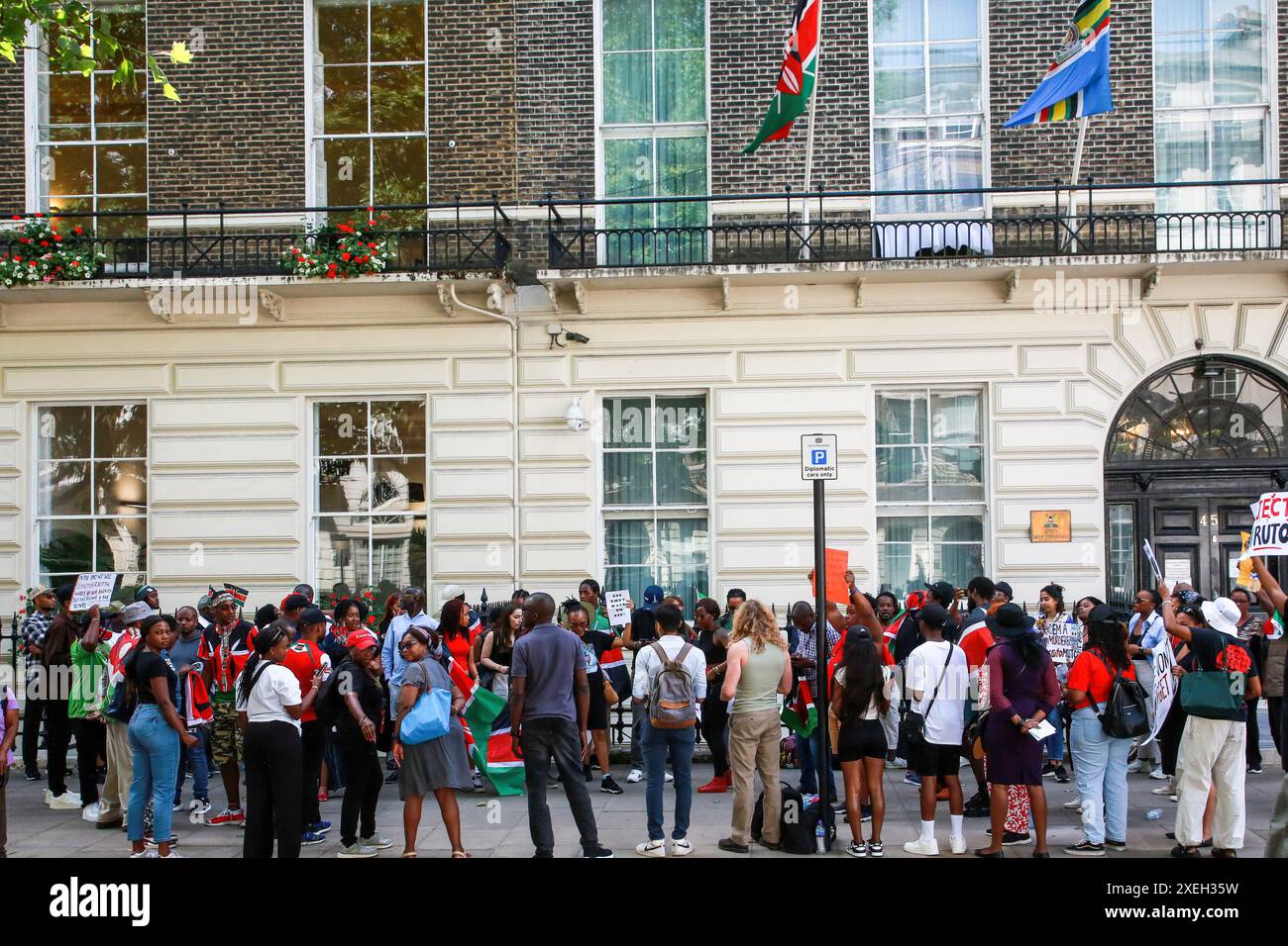 Londres, Royaume-Uni. 27 juin 2024. Les manifestants écoutent les orateurs pendant la manifestation. Les manifestants se sont rassemblés devant le Haut-commissariat du Kenya après que le gouvernement kenyan ait présenté un projet de loi de finances destiné à augmenter ou à introduire des taxes ou des frais sur une gamme d'articles quotidiens, y compris les données Internet, le carburant, les virements bancaires. Crédit : SOPA images Limited/Alamy Live News Banque D'Images