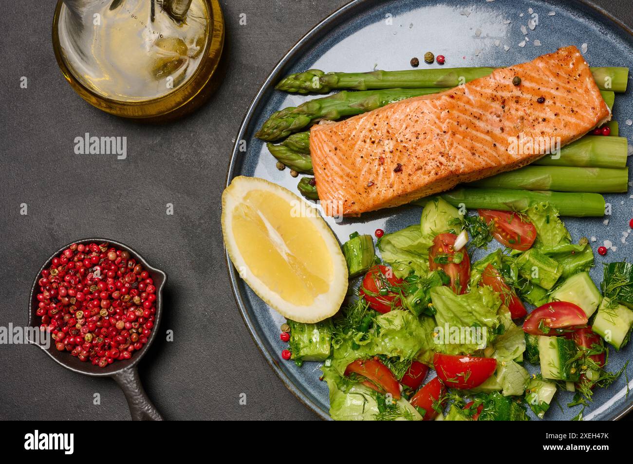 Déjeuner sain avec saumon grillé aux asperges et salade de tomates fraîches et de concombre Banque D'Images