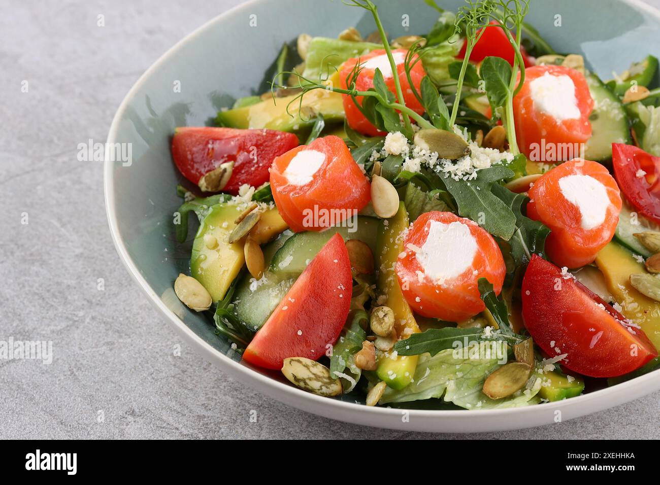 Salade de saumon aux feuilles vertes, avocat et tomate sur fond de pierre noire. Vue de dessus avec espace de copie. Banque D'Images