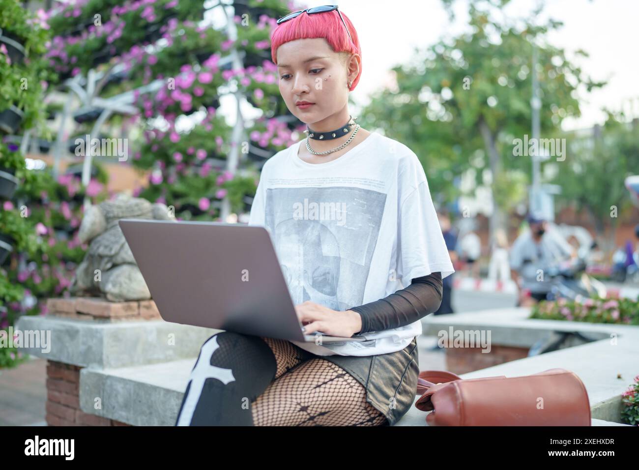 Gen z fille mode en cuir avec femme asiatique punk travaillant à distance sur ordinateur portable nomade numérique en Thaïlande Banque D'Images