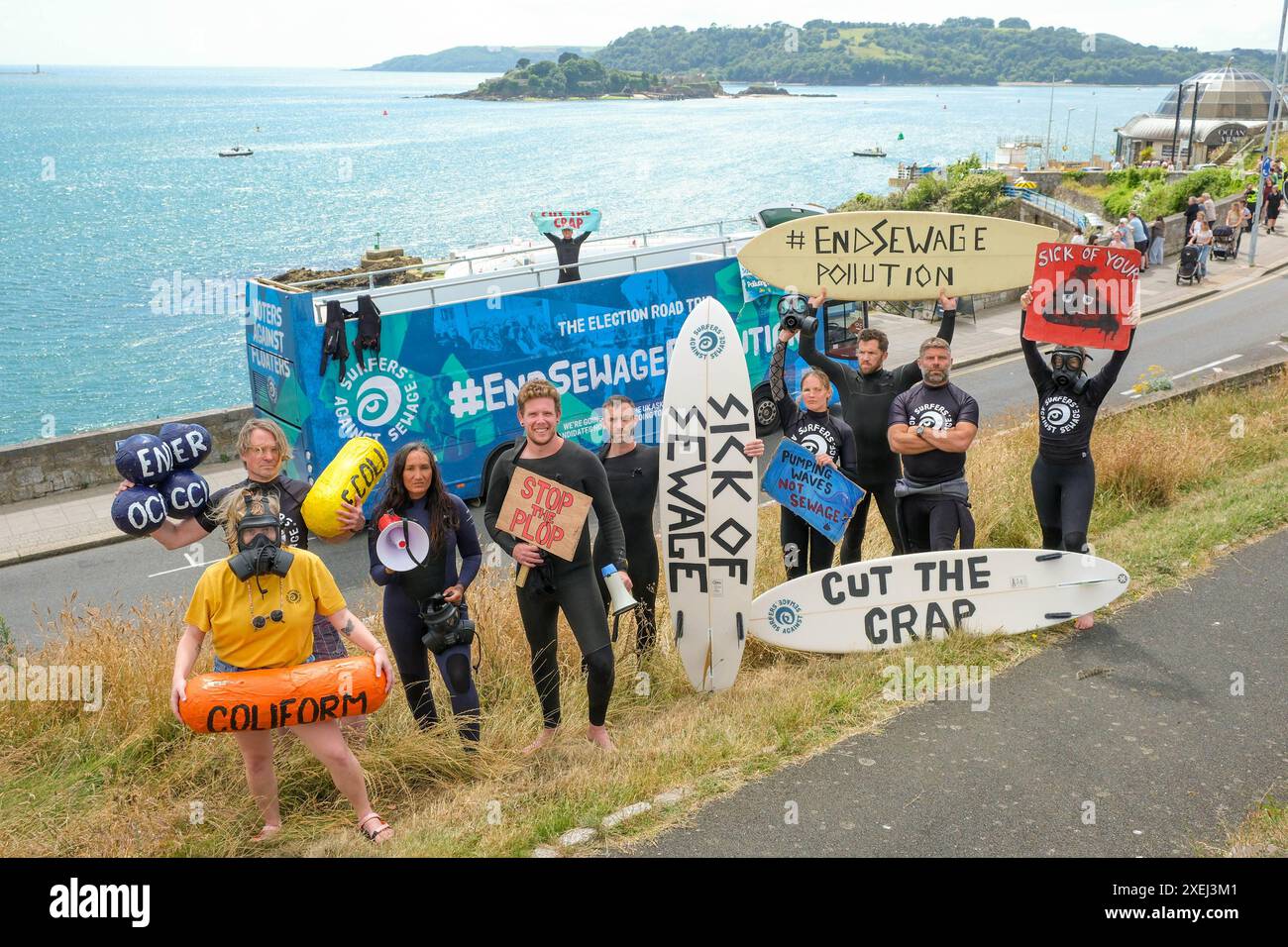 ÉDITORIAL UTILISEZ UNIQUEMENT les militants de Surfers contre les eaux usées et leur bus de tournée électorale de fin de pollution des eaux usées à Plymouth Hoe, l'un des lieux de baignade les plus pollués par les eaux usées en Angleterre et au pays de Galles. Date d'émission : vendredi 28 juin 2024. Banque D'Images