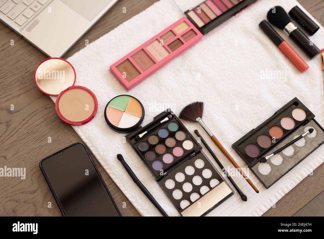 Produits de maquillage et smartphone sur table, prêt pour la routine beauté à la maison Banque D'Images