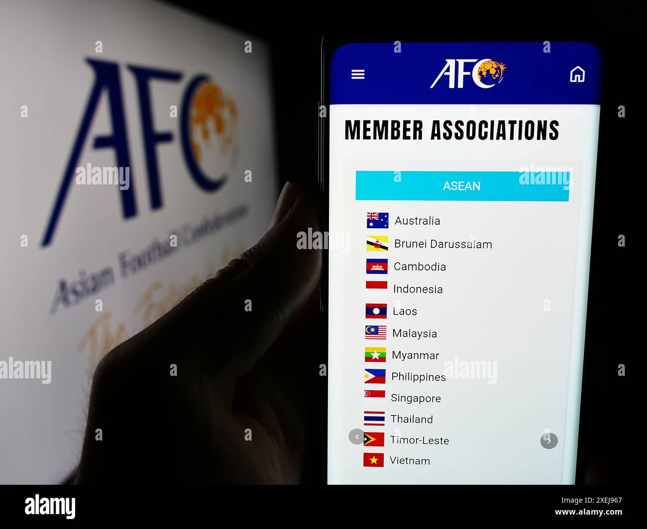 Personne tenant le téléphone portable avec la page Web de l'association Confédération asiatique de football (AFC) devant le logo. Concentrez-vous sur le centre de l'écran du téléphone. Banque D'Images