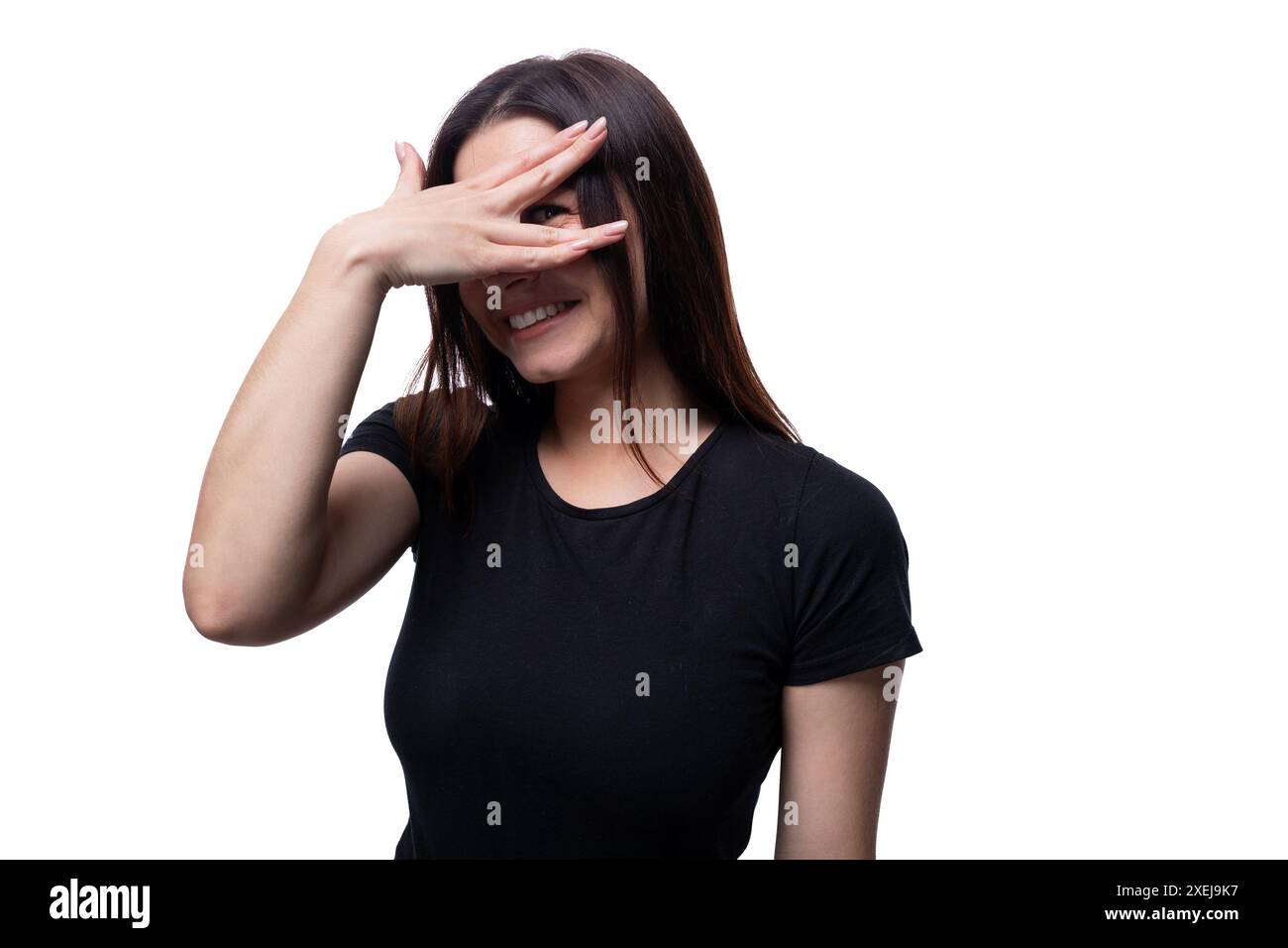 femme mignonne de 25 ans avec les cheveux noirs droits cache son visage avec ses mains Banque D'Images