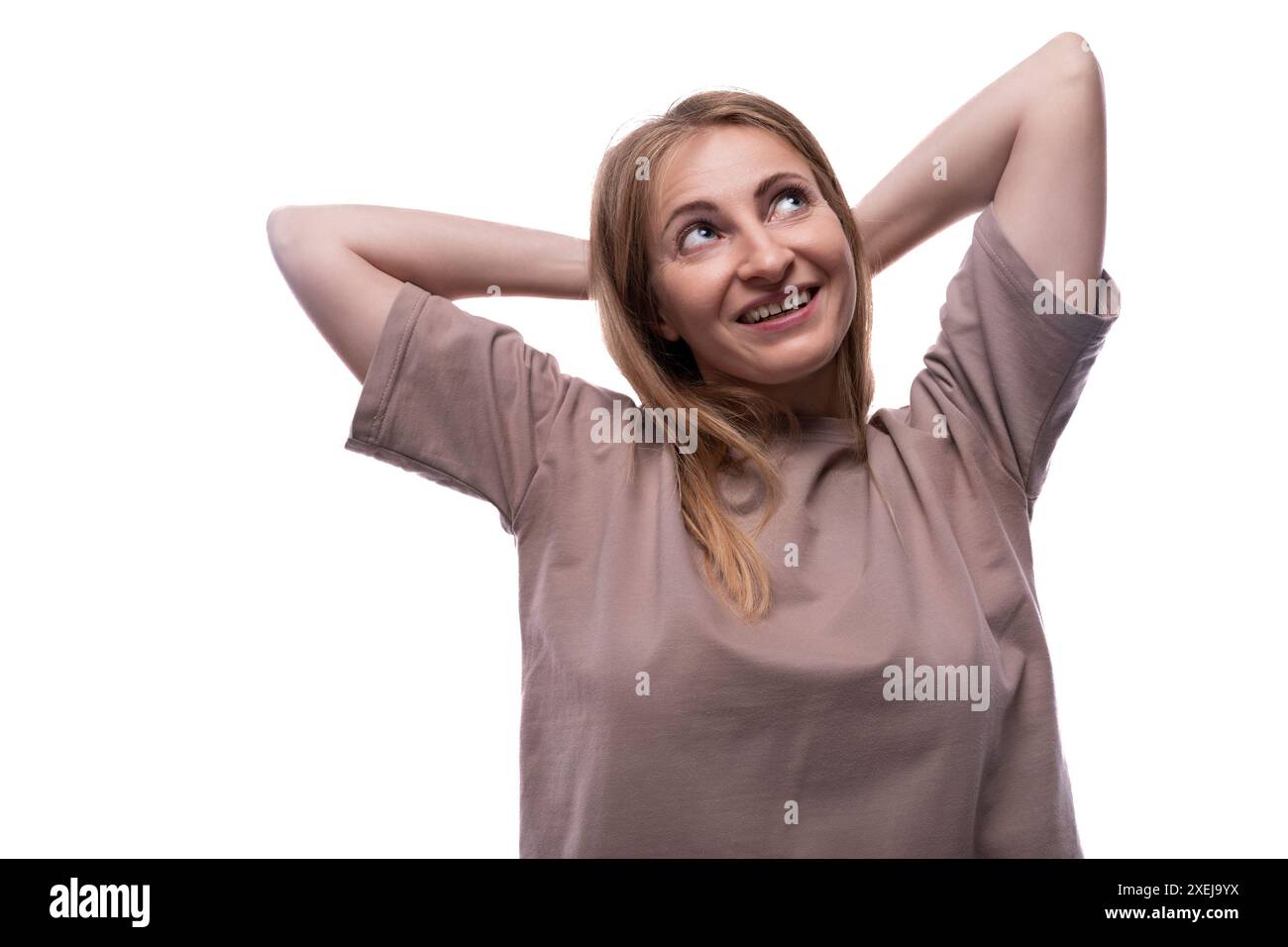 Portrait d'une femme rêveuse de 40 ans avec des cheveux blonds coulants regardant vers le haut Banque D'Images