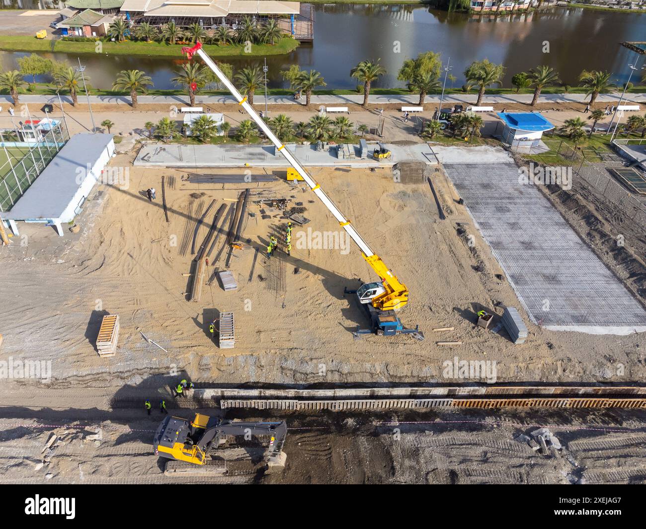 Travaux de construction au bord de la mer. La machinerie lourde travaille à renforcer les fondations de l'eau et des vagues de tempête. Vue depuis le drone. Banque D'Images