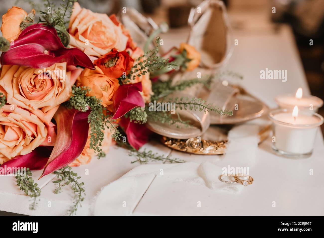 Bouquet avec anneaux de mariage, bougies et chaussures Banque D'Images