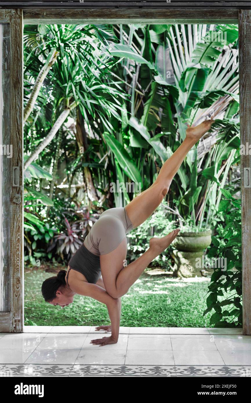 Jeune femme concentrée avec les yeux fermés pratiquant le yoga Banque D'Images