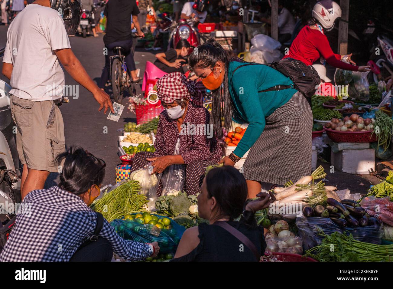 Transaction en espèces, vendeur de légumes cambodgien portant un masque pendant la pandémie COVID-19. Le marché russe, Phnom Penh, Cambodge. © Kraig Lieb Banque D'Images