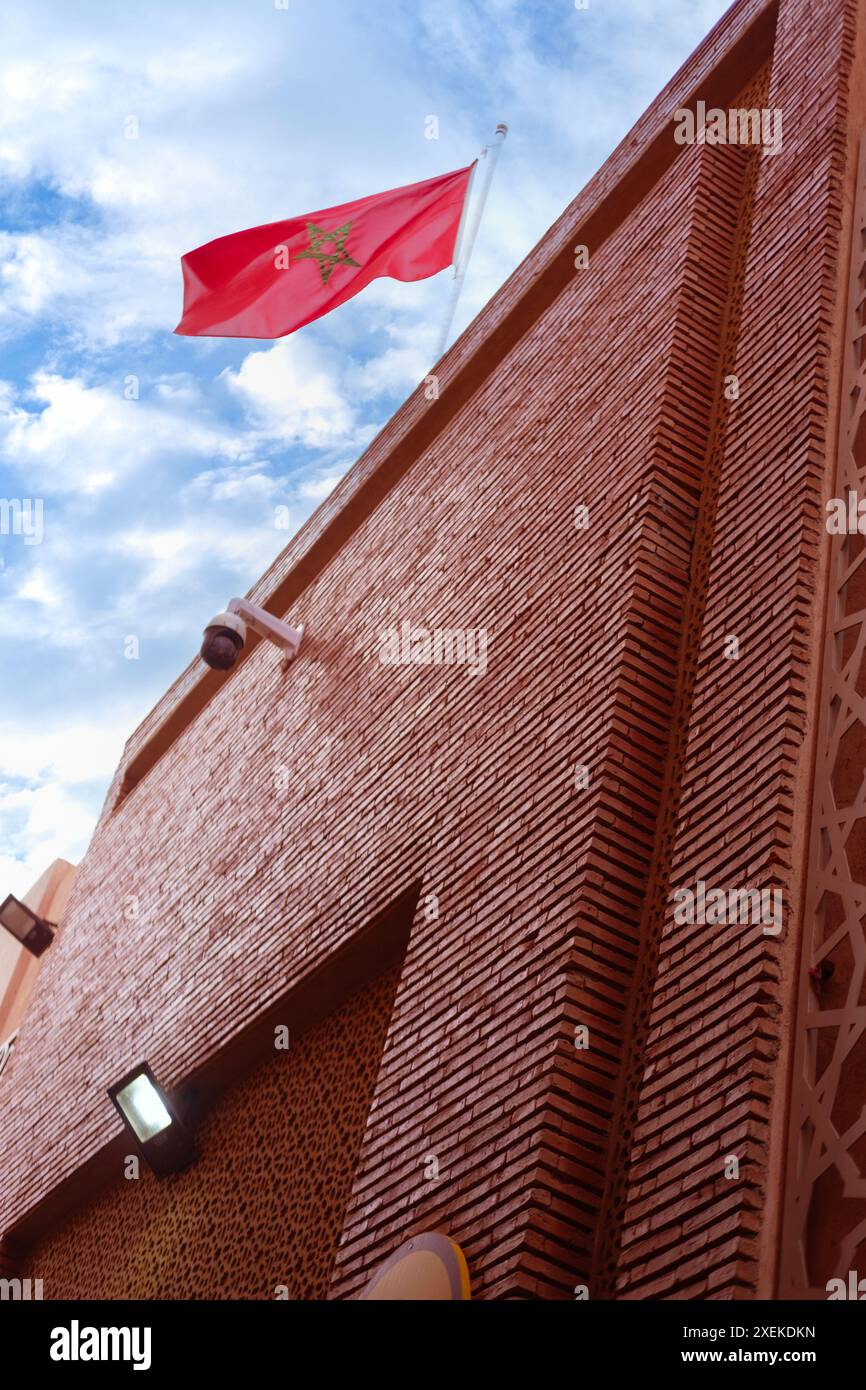 Drapeau national marocain rouge flattes tissu de soie contre le ciel, étoile à cinq branches, bâtiment du gouvernement, jour de l'indépendance, commerce mondial, affaires et cou Banque D'Images