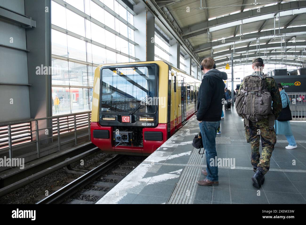 Le train régional Deutsche Bahn arrive à la gare de Berlin, passagers en attente sur le quai, retard des transports publics, trajet quotidien, Berlin - 25 avril 2024 Banque D'Images