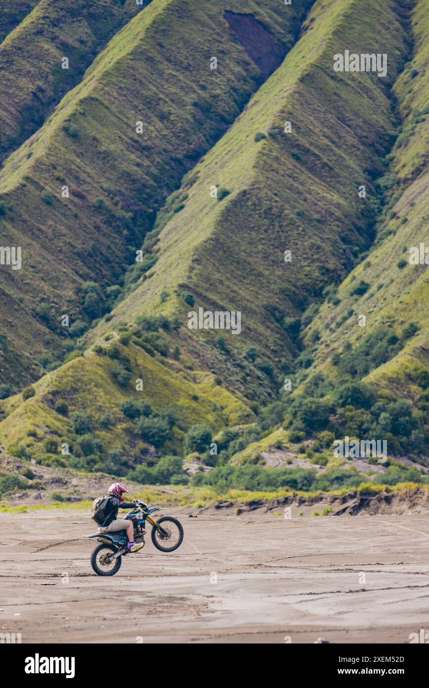 Promenades en moto sur la mer de sable dans le parc national bromo Tengger Semeru, avec le massif Tengger en arrière-plan, Java oriental, Indonésie Banque D'Images