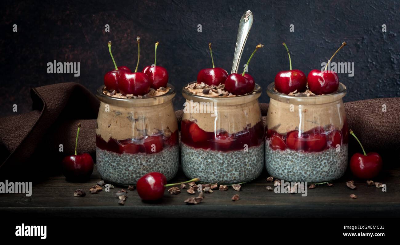 Puddings de chia de forêt noire dans une rangée, sur un fond sombre. Banque D'Images