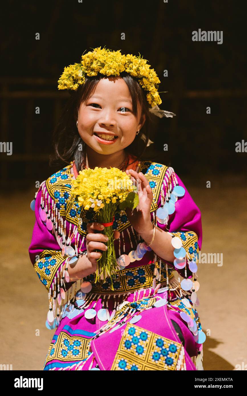 Portrait d'une fille Hmong avec guirlande florale et bouquet ; Pa Co, mai Chau, son la, Vietnam Banque D'Images