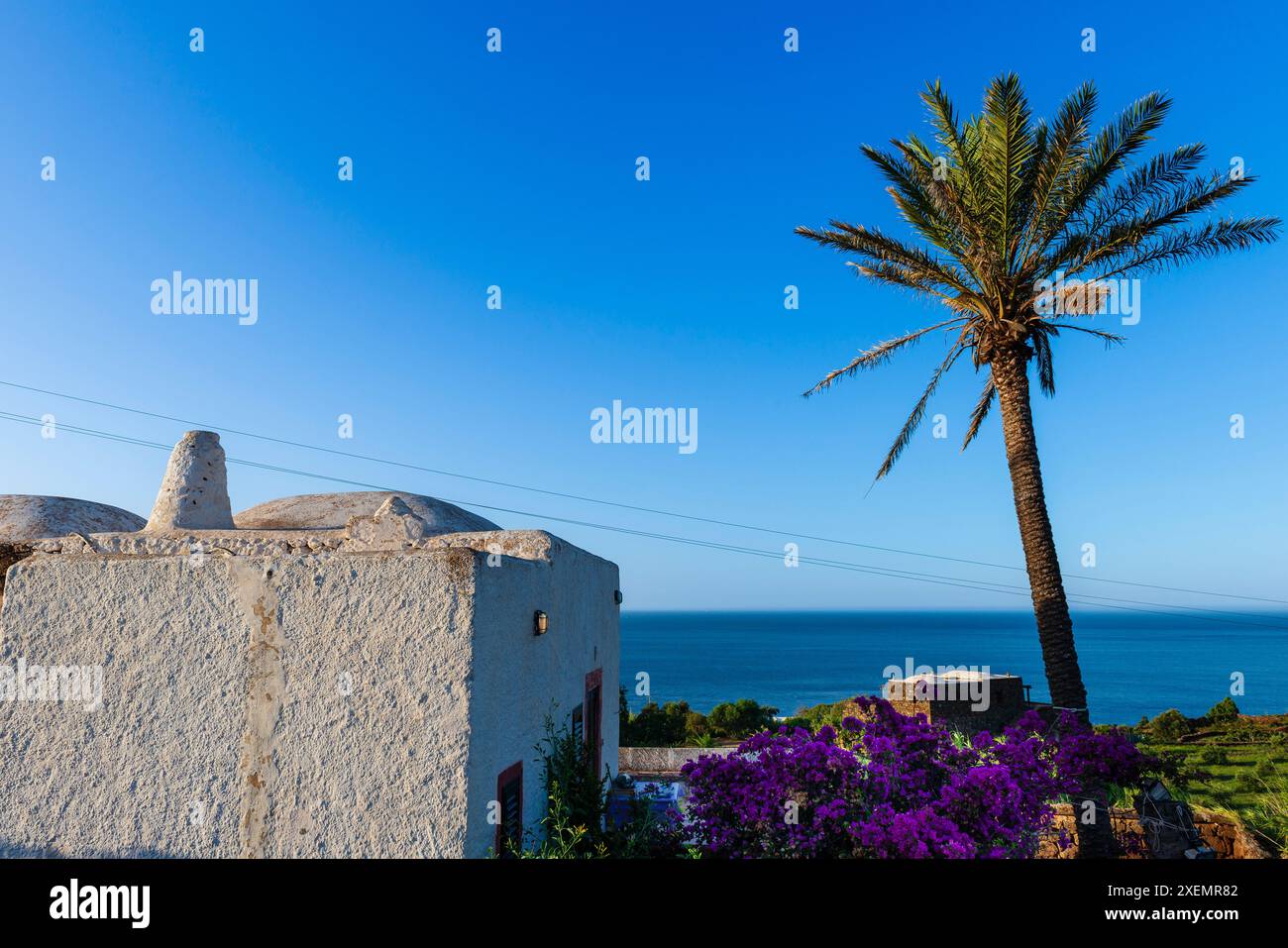 Dammuso, une maison typique sur l'île de Pantelleria, avec une vue sur la mer Méditerranée et le ciel bleu clair ; Pantelleria, Sicile, Italie Banque D'Images