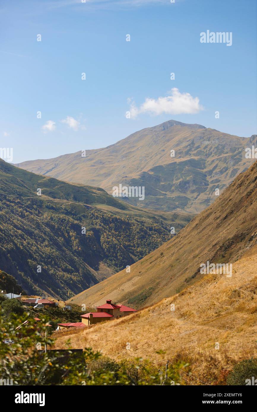 Maisons dans une vallée parmi les montagnes du parc national de Kazbegi ; Géorgie Banque D'Images