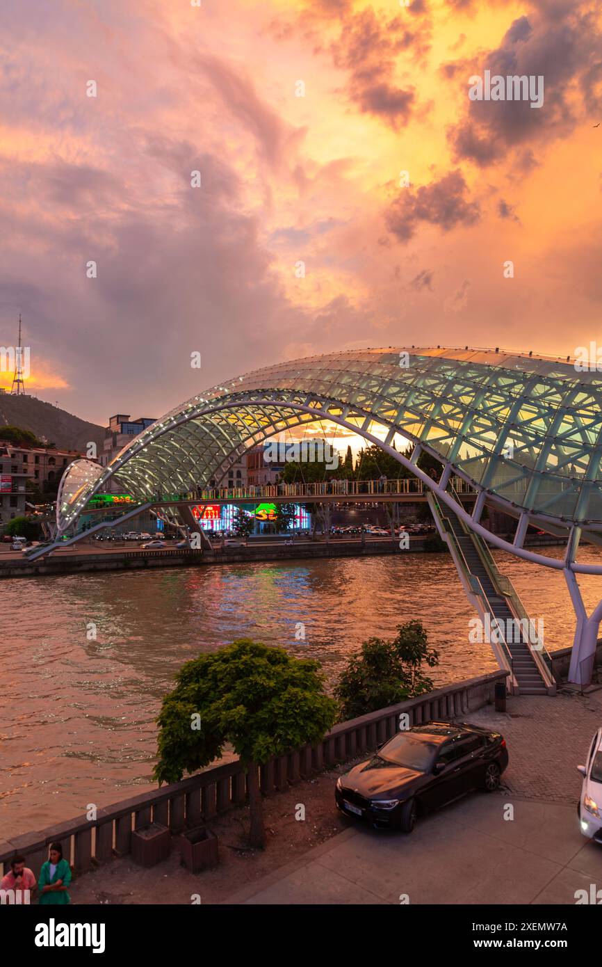 Tbilissi, Géorgie - 16 juin 2024 : le pont de la paix est un pont piétonnier en forme d'arc, une construction en acier et en verre au-dessus de la rivière Kura, reliant t Banque D'Images