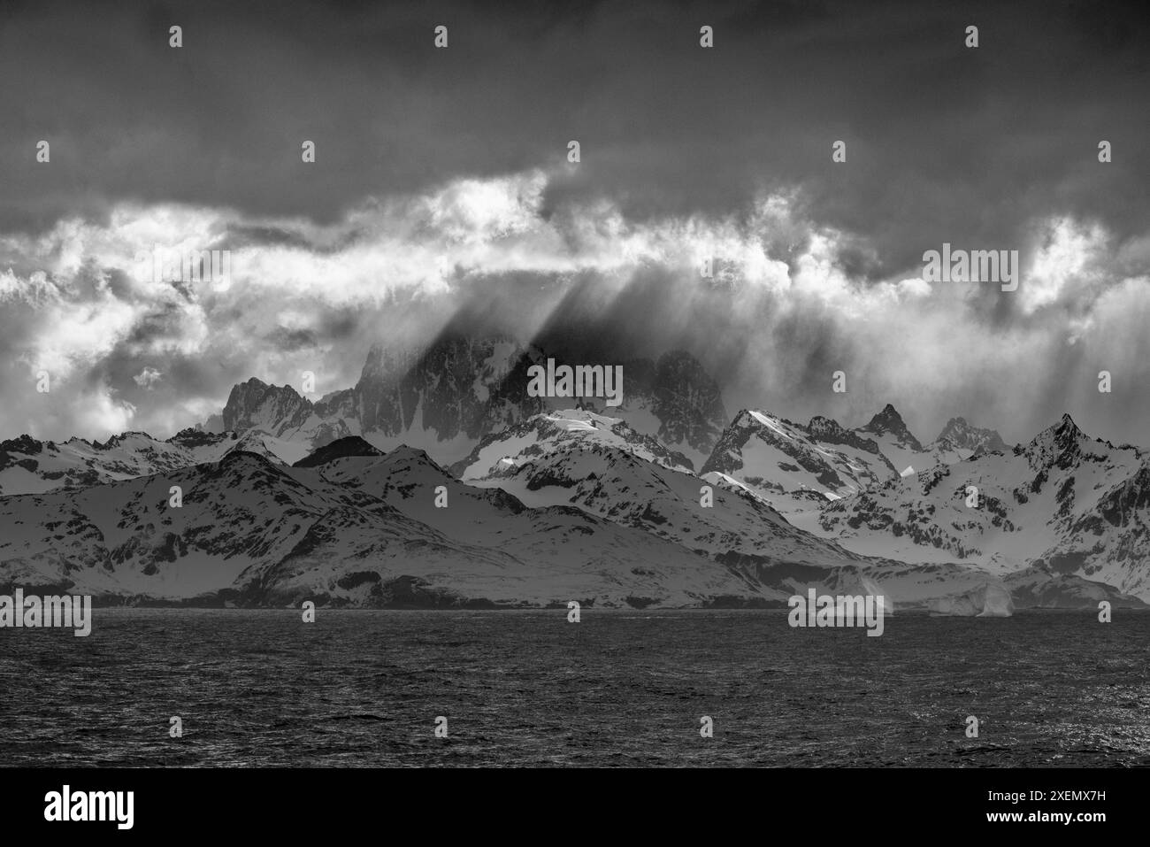 Île de Géorgie du Sud. Ouverture dans les nuages et Virga révèlent le paysage montagneux et glaciaire. Banque D'Images