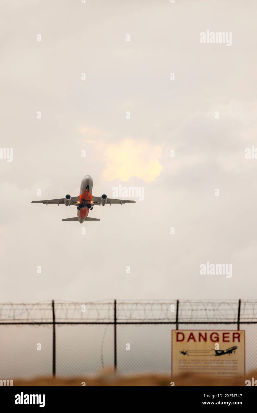 Vue d'un avion contre un ciel nuageux survolant l'aéroport international de Phuket depuis mai Khao Beach dans le nord de Phuket ; mai Khao, Phuket, Thaïlande Banque D'Images