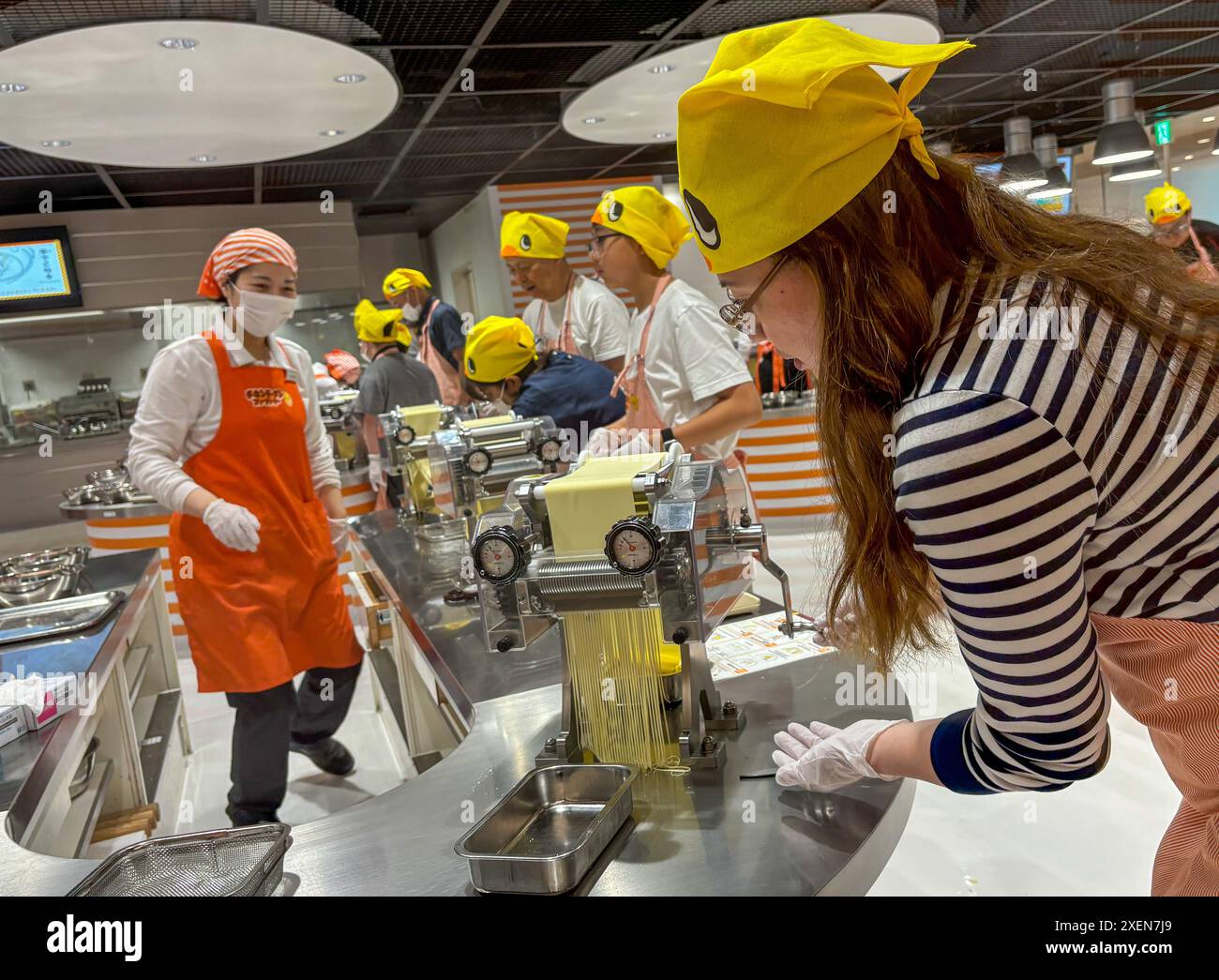 Un visiteur a vu rouler la pâte à nouilles pendant le processus de production de nouilles instantanées au musée CupNoodles. Le musée est dédié à l'histoire des nouilles instantanées et à l'histoire de Nissin Foods, fondée par Momofuku Ando, l'inventeur des nouilles instantanées et des CupNoodles. Le musée a deux emplacements, l'un à Osaka et l'autre à Yokohama, au Japon. (Photo de Pongmanat Tasiri/SOPA images/Sipa USA) crédit : Sipa USA/Alamy Live News Banque D'Images