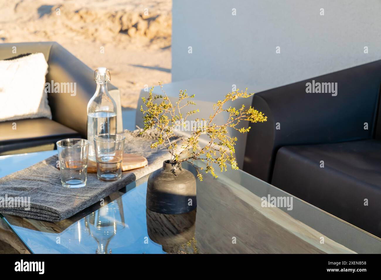Table extérieure moderne verre verres bouteille d'eau et vase à Joshua Tree, Californie Banque D'Images