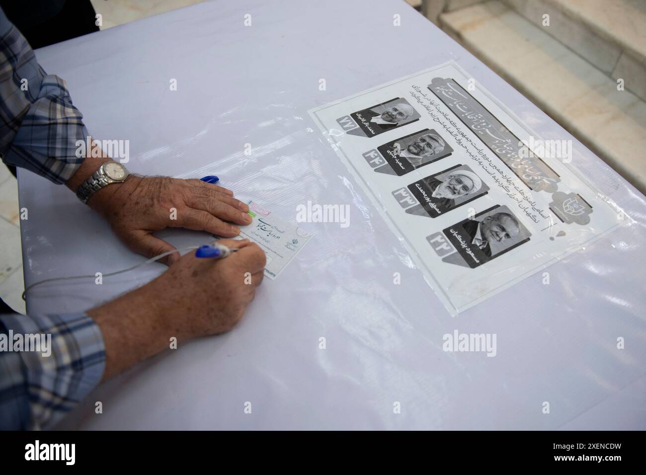 Téhéran, Iran. 28 juin 2024. Un homme remplit son bulletin de vote lors de l'élection présidentielle iranienne dans un bureau de vote au sanctuaire Shah Abdol-Azim, au sud-est de Téhéran, Iran, vendredi 28 juin, 2024. les Iraniens ont voté vendredi lors d'élections anticipées pour remplacer feu le Président Ebrahim Raisi. (Photo de Sobhan Farajvan/Pacific Press) crédit : Pacific Press Media production Corp./Alamy Live News Banque D'Images