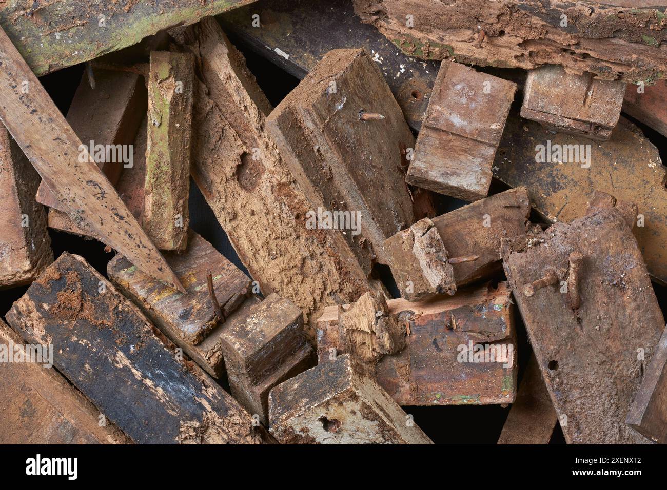 pile de morceaux de bois grattés avec des clous en arrière-plan plein cadre, laissés sur des blocs de bois délabrés ou pourris provenant de la construction, inutilisables Banque D'Images