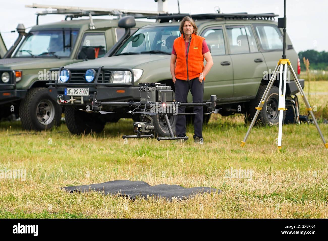 Drohne zur Suche von Tierkadavern und Wildschweinrotten hebt ab am mobilen Leitzentrum. Mobile Einsatzzentrale der Drohnenpiloten an der Weiterstädter Kellerranch zum Aufspüren von Wildschweinrotten und Tierkadavern wegen der afrikanischen Schweinepest im Landkreis Darmstadt-Dieburg. Geschäftsführer Pro Schutz Peter Schließmann sieht zu - Weiterstadt 29.06.2024 : Mobile Einsatzzentrale der Drohnenpiloten *** drone à la recherche de carcasses d'animaux et de carcasses de sangliers décolle au centre de contrôle mobile le centre d'opérations mobile des pilotes de drones à la Weiterstadt Kellerranch pour traquer Banque D'Images