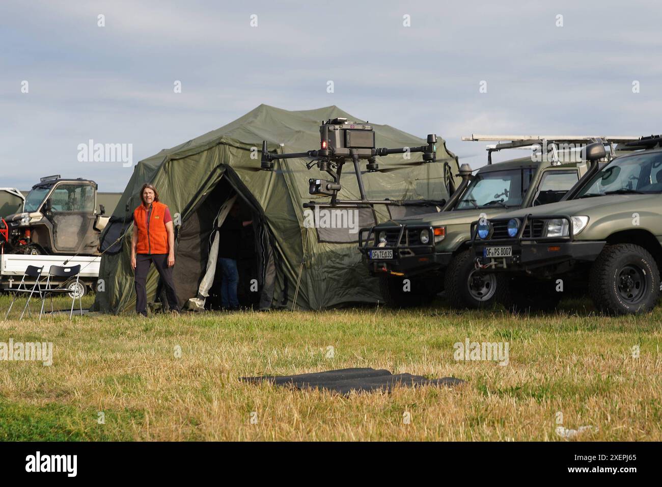 Drohne zur Suche von Tierkadavern und Wildschweinrotten hebt ab am mobilen Leitzentrum. Mobile Einsatzzentrale der Drohnenpiloten an der Weiterstädter Kellerranch zum Aufspüren von Wildschweinrotten und Tierkadavern wegen der afrikanischen Schweinepest im Landkreis Darmstadt-Dieburg. Geschäftsführer Peter Schließmann schaut zu - Weiterstadt 29.06.2024 : Mobile Einsatzzentrale der Drohnenpiloten *** le drone à la recherche de carcasses d'animaux et de carcasses de sangliers décolle au centre de contrôle mobile le centre d'opérations mobile des pilotes de drones à la Kellerranch à Weiterstadt pour traquer les animaux sauvages b Banque D'Images