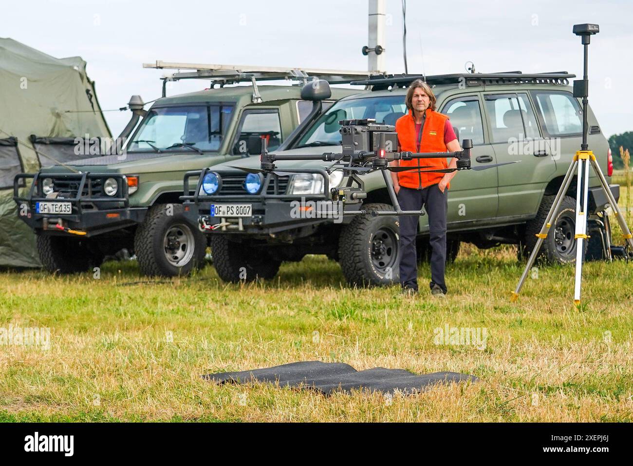 Drohne zur Suche von Tierkadavern und Wildschweinrotten hebt ab am mobilen Leitzentrum. Mobile Einsatzzentrale der Drohnenpiloten an der Weiterstädter Kellerranch zum Aufspüren von Wildschweinrotten und Tierkadavern wegen der afrikanischen Schweinepest im Landkreis Darmstadt-Dieburg. Geschäftsführer Pro Schutz Peter Schließmann sieht zu - Weiterstadt 29.06.2024 : Mobile Einsatzzentrale der Drohnenpiloten *** drone à la recherche de carcasses d'animaux et de carcasses de sangliers décolle au centre de contrôle mobile le centre d'opérations mobile des pilotes de drones à la Weiterstadt Kellerranch pour traquer Banque D'Images