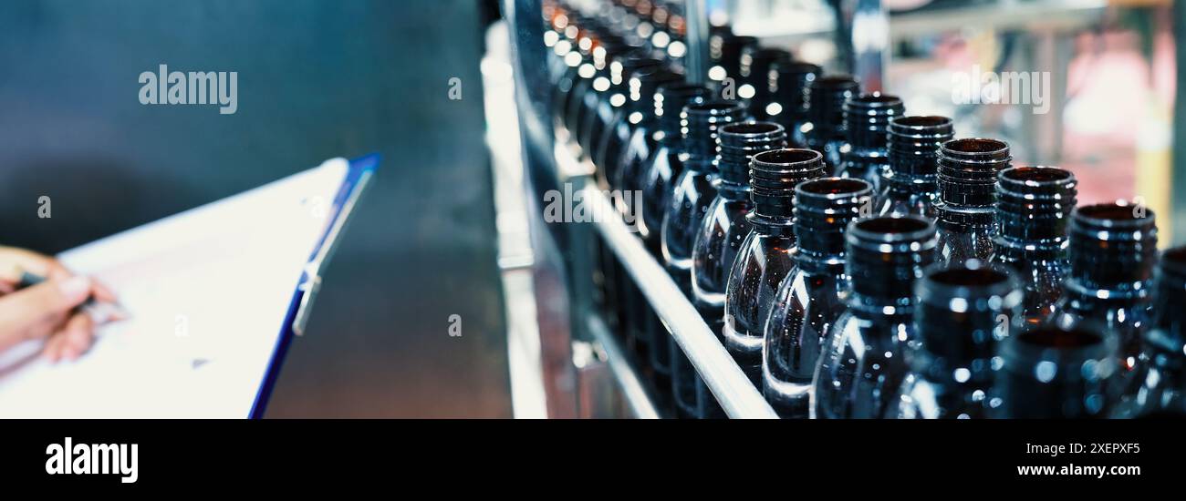 Machine d'automatisation de remplissage de bouteilles dans l'usine moderne. Démonstration technologique de bouteilles de remplissage et de bouchage dans l'industrie. Inspection des flacons pour Banque D'Images