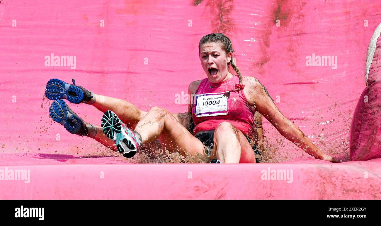 Brighton UK 29 juin 2024 - des milliers de personnes participent à l'événement cancer Research UK Pretty Muddy Race for Life par une chaude journée ensoleillée à Stanmer Park Brighton . Les participants qui ont été touchés par le cancer font leur chemin autour du parcours Pretty Muddy obstacle qui est un peu plus de 3 miles et aide à lever des milliers de livres pour cancer Research UK : crédit Simon Dack / Alamy Live News Banque D'Images